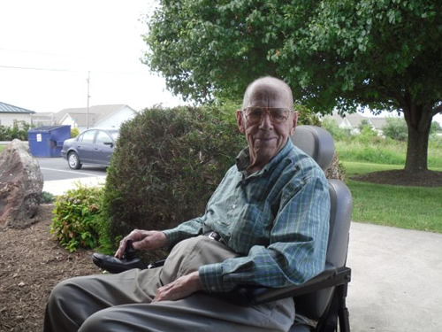 old man with glasses sitting on a chair