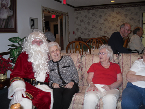 a portrait of santa claus and group of elderly people