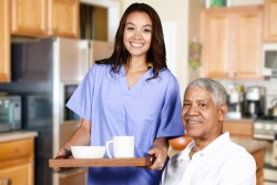 caregiver helping an elderly man