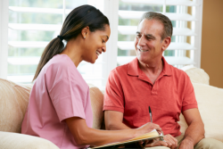 elderly man talking to his caregiver and smiling